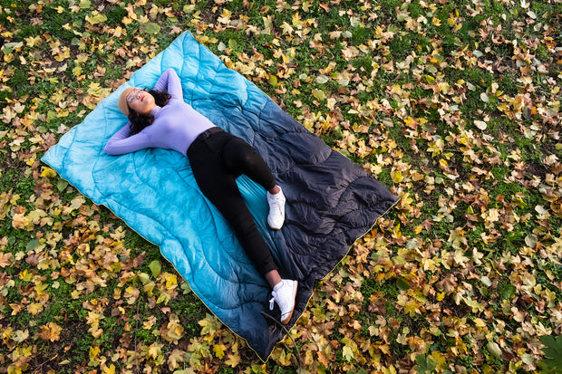 Frau liegend auf der blauen HÄNG DÄCKE im Herbst auf Laub 